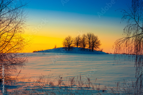 Naklejka na drzwi Sunset over snowy field