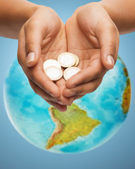 Poster - cupped hands holding euro coins over earth globe