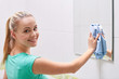 © Syda Productions - happy woman cleaning mirror with rag