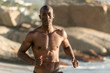 © softfocusphoto - Topless, muscular black man running on beach