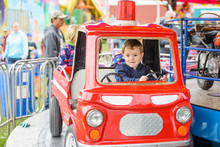 Boy Smiling On A Merry-Go-Round Firetruck