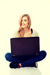 © Piotr Marcinski - Smiling woman using a laptop
