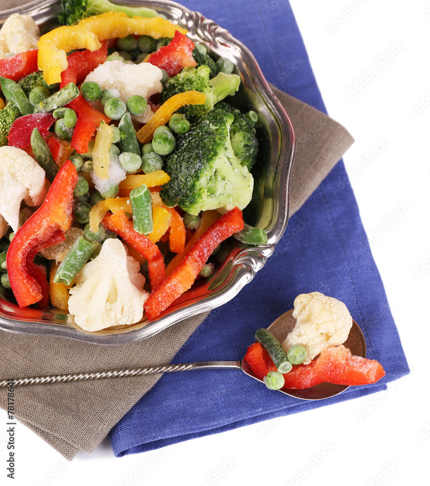 Frozen vegetables in bowl on napkin, isolated on white