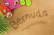 The word Bermuda written in sand on a beach with towel flip flops seashells summer vacation holiday photo