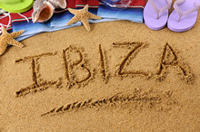 The Word Ibiza Written In Sand On A Beach With Towel Flip Flops Seashells Summer Vacation Holiday Photo