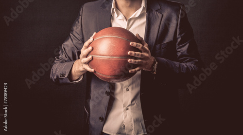 Leinwand Poster  mature businessman holding basketball ball