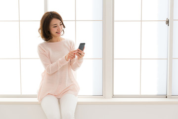 Wall Mural - young asian woman using smart phone