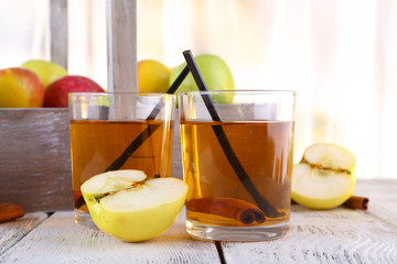 still life with apple cider and fresh apples on wooden table