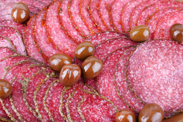 Wall Mural - Slices of salami with olives, macro view