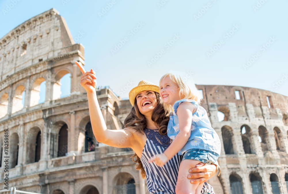 Happy mother and baby girl sightseeing near colosseum in rome