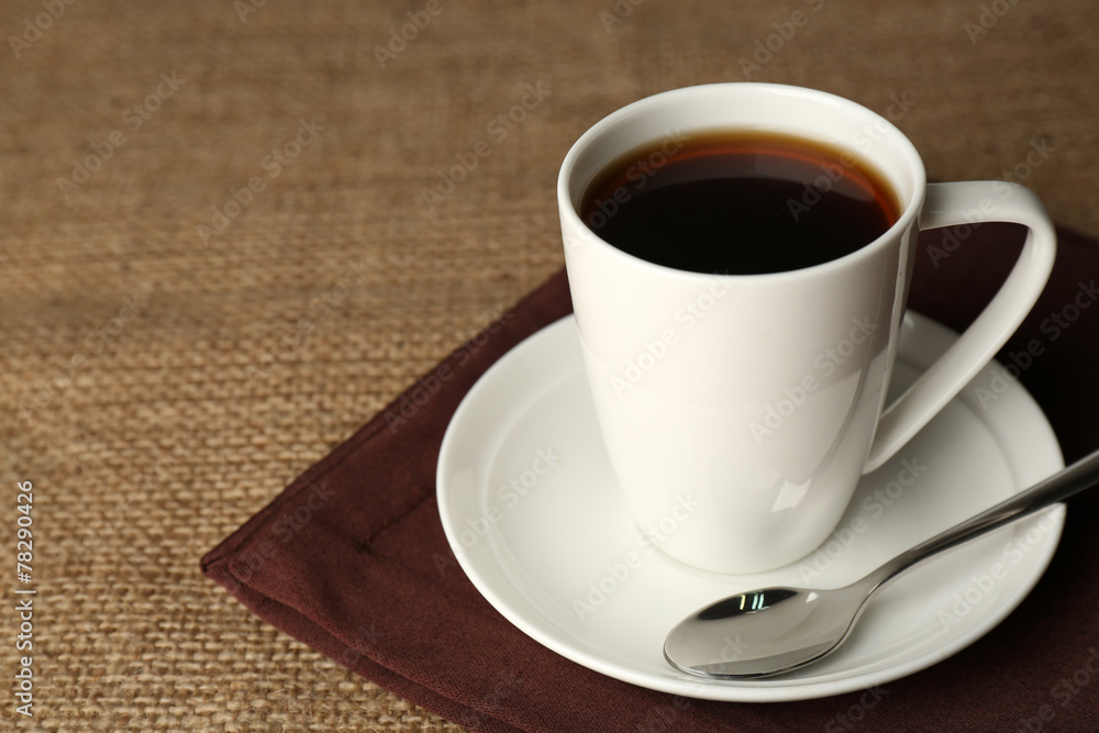 Cup of coffee with beans on rustic wooden background