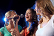 © Syda Productions - happy young women singing karaoke in night club