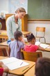 © WavebreakMediaMicro - Teacher and pupils working at desk together