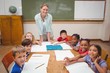 © WavebreakMediaMicro - Teacher and pupils working at desk together