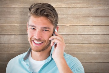 Poster - Composite image of handsome young man talking on his smartphone