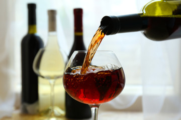 Canvas Print - Red wine pouring into wine glass, close-up