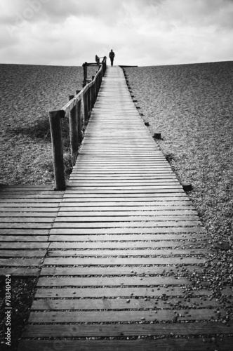 Obraz w ramie Man walking alone on jetty