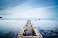 Wooden Pier Or Jetty On A Blue Ocean In The Morning.Long Exposur