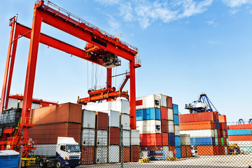 Pier under the blue sky, cranes and containers.