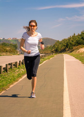 Young woman with earphones listening music and running