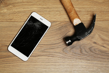 Canvas Print - Broken iPhone with hammer on wooden background