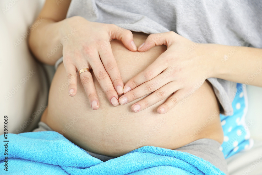 Young pregnant woman relaxing on sofa, close-up