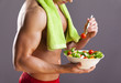 © cristovao31 - Fit man holding a bowl of fresh salad on grey background
