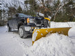 Pickup truck plowing snow
