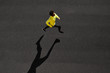 Top view athlete runner training at black road in yellow