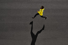Top View Athlete Runner Training At Black Road In Yellow