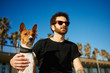 © wayhome.studio  - Strong bearded man in sunglasses sitting in sand with friend dog