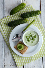 Canvas Print - Cucumber soup in bowl on color wooden table background