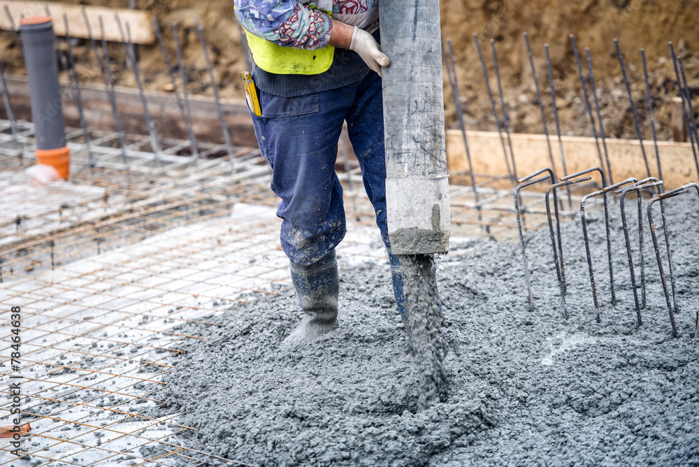 construction worker pouring cement or concrete with pump tube - obrazy, fototapety, plakaty 