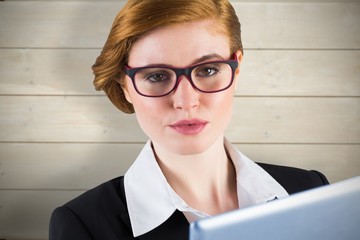 Poster - Composite image of redhead businesswoman using her tablet pc