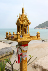 traditional Thai spirit house in front of sea landscape