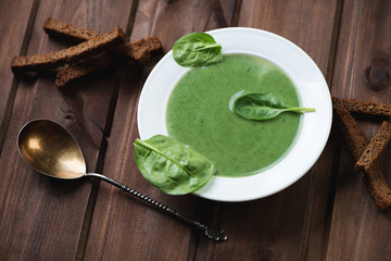 Wall Mural - Freshly made spinach cream soup over rustic wooden background