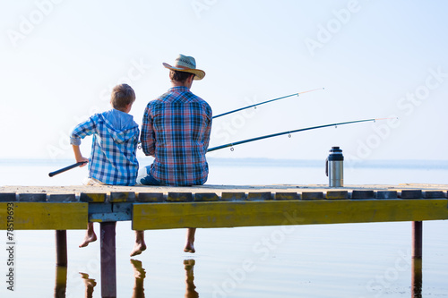 Fotografija  boy and his father fishing togethe