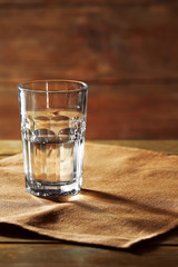 Wall Mural - Glass of water on table on wooden background