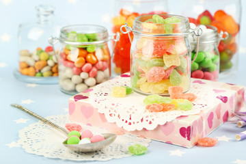 Sticker - Multicolor candies in glass jars on colorful background