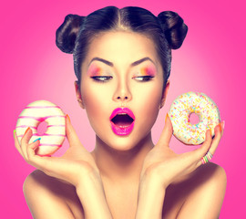 Wall Mural - Beauty fashion model girl taking sweets and colorful donuts