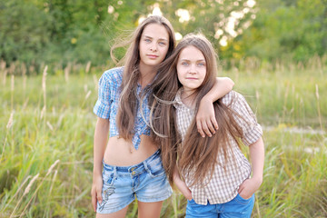 Portrait of two beautiful girlfriends on the nature