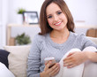 © shefkate - Pretty girl using her smartphone on  couch at home in the living