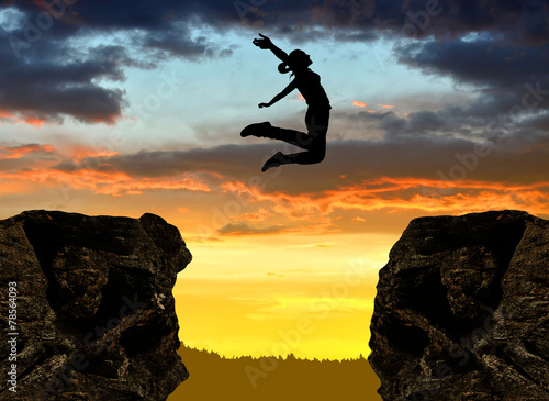 Silhouette the girl jumping over the gap at sunset Poster