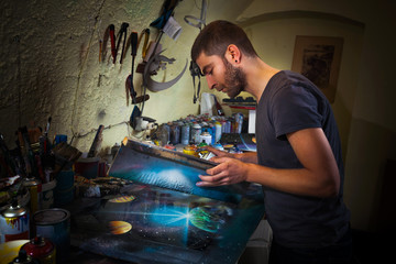 Wall Mural - Young artist working in his studio creating spray paint art.