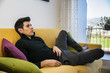 © theartofphoto - Young man at home sitting on couch watching television
