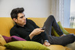 © theartofphoto - Young man sitting on couch watching television