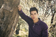 © theartofphoto - Handsome young man leaning against olive tree