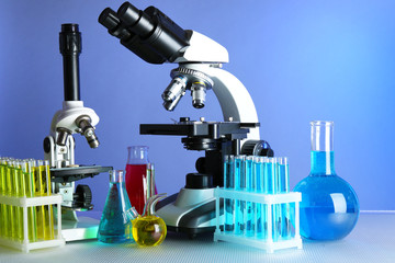 Wall Mural - microscopes and test tubes on table, on color background