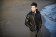 © theartofphoto - Attractive young man at the seaside on the beach wearing black