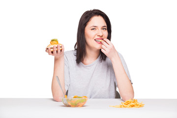 picture of woman with fruits and hamburger in front on white bac